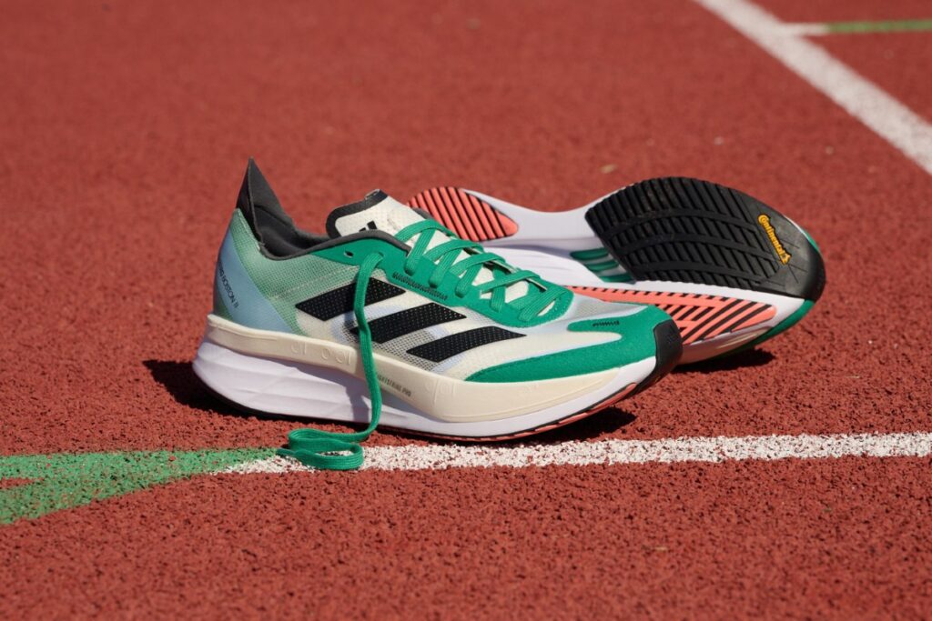 adidas boston 11 running shoe on a running track with another shoe in the background